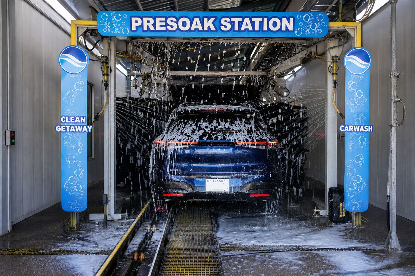 Dark SUV covered in foam inside the wash tunnel under the Presoak Station sign